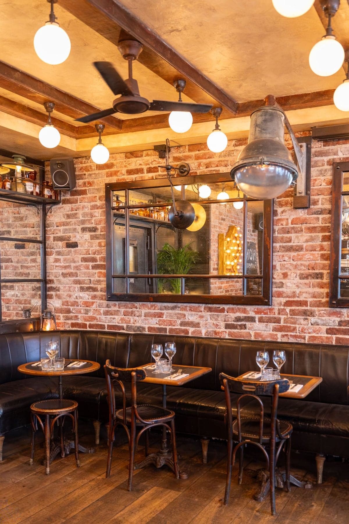 The Le Compas dining room, exposed brick, mirrors and wooden tables