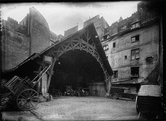Old photograph of the courtyard stagecoach shed with its arched timber frame